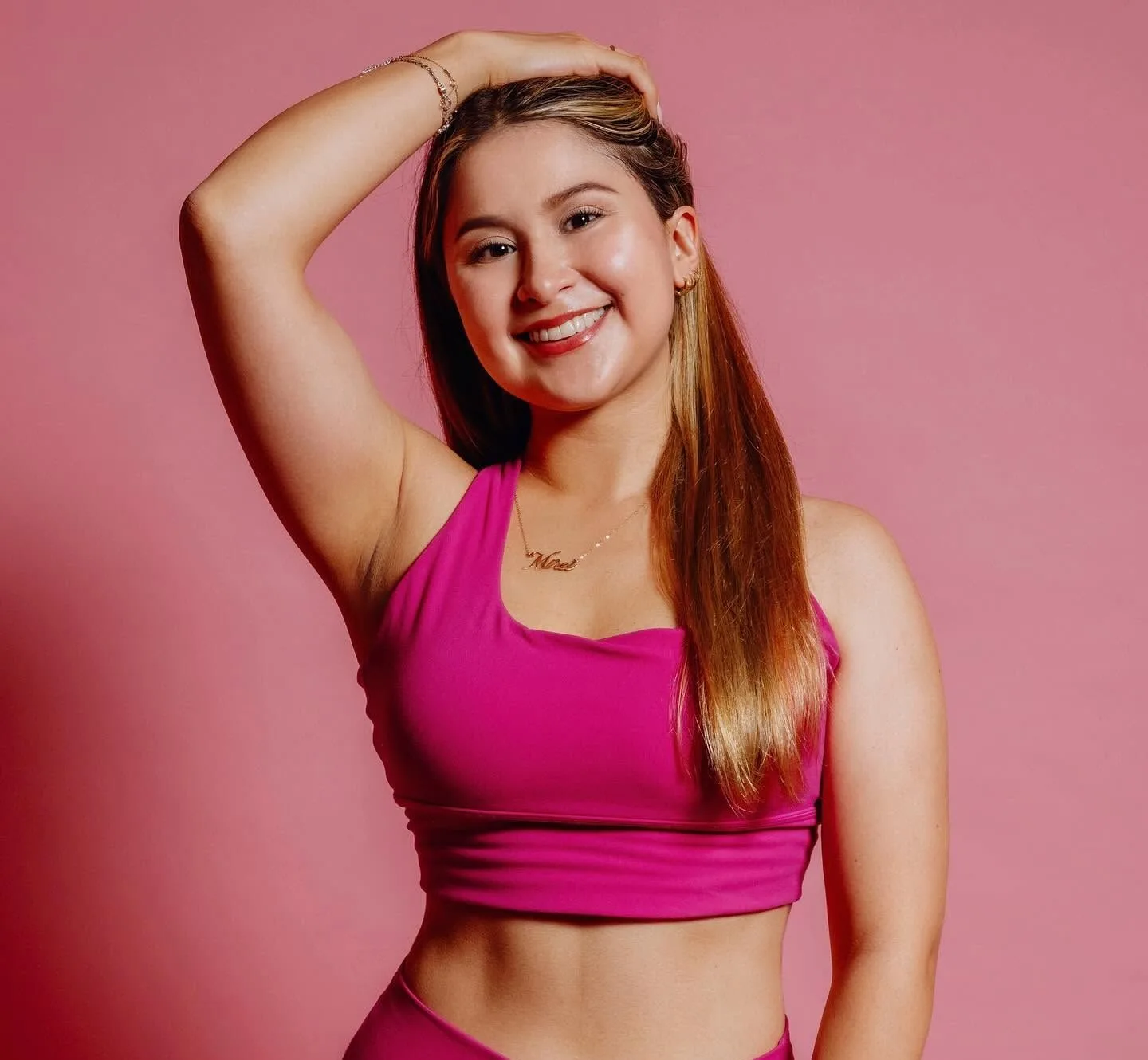 La nutrióloga sonriendo en su outfit rosa